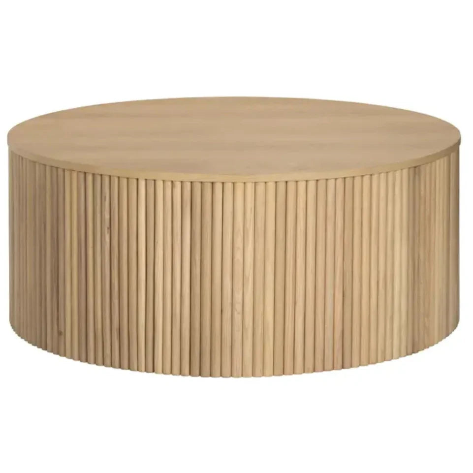 Natural light wood round coffee table with a fluted slat base in a modern boho style.