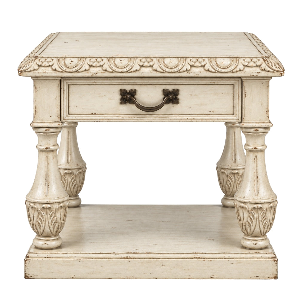 A distressed white carved wooden end table with a single drawer, ornate legs, and a lower shelf, shown against a plain white background.