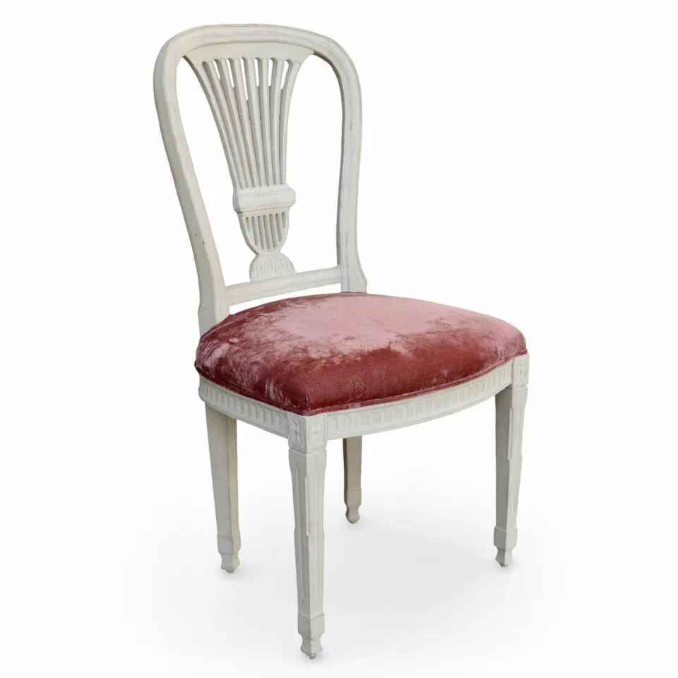 French country style dining chair with white distressed wood frame and pink velvet upholstery.