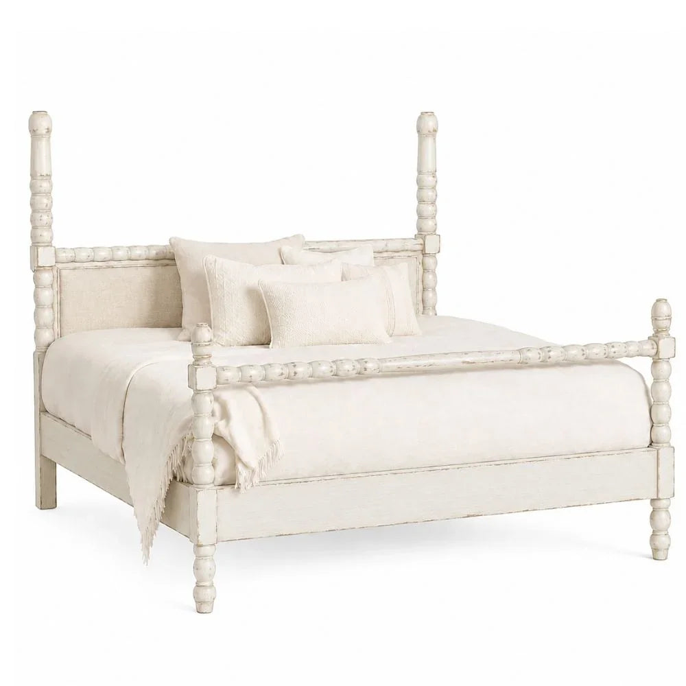 A distressed white four-poster bed frame with matching cream bedding and pillows, shown on a solid white background.