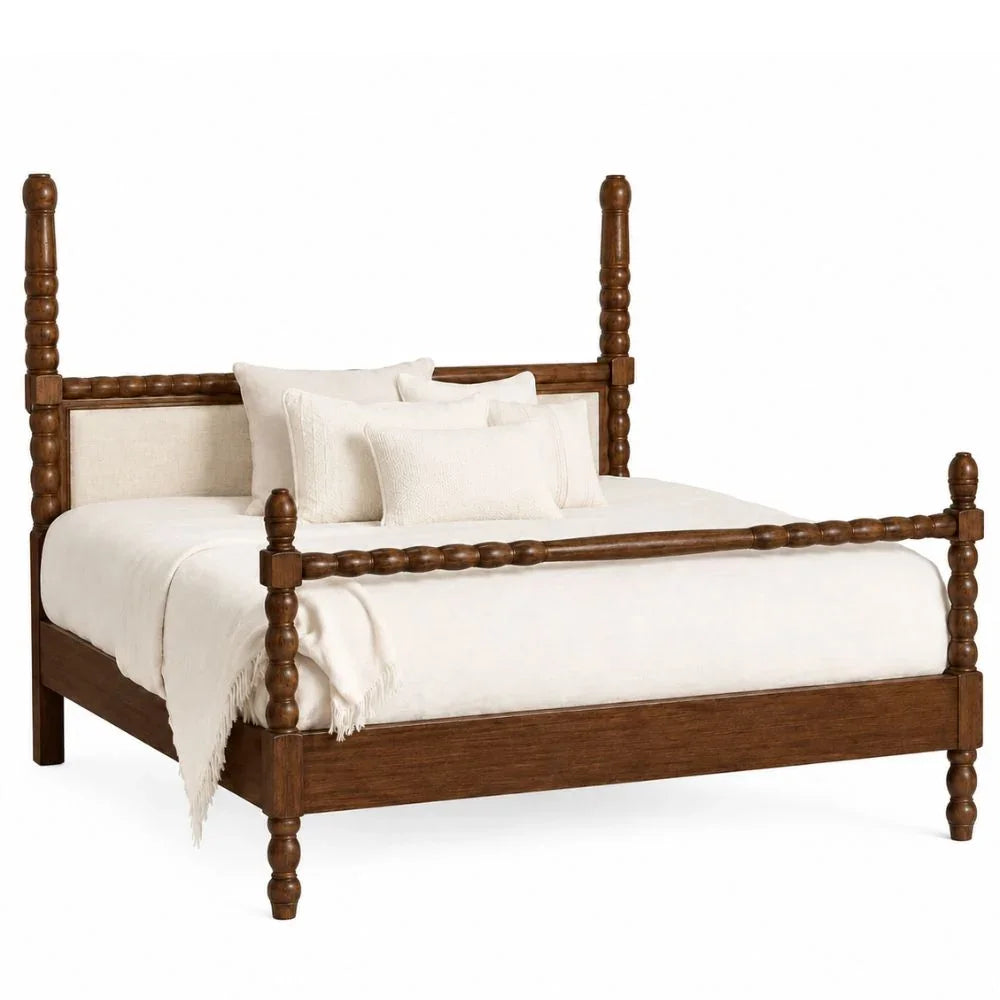 A wooden four-poster bed frame with turned posts and a upholstered headboard, shown with white bedding and pillows on a clean white background.