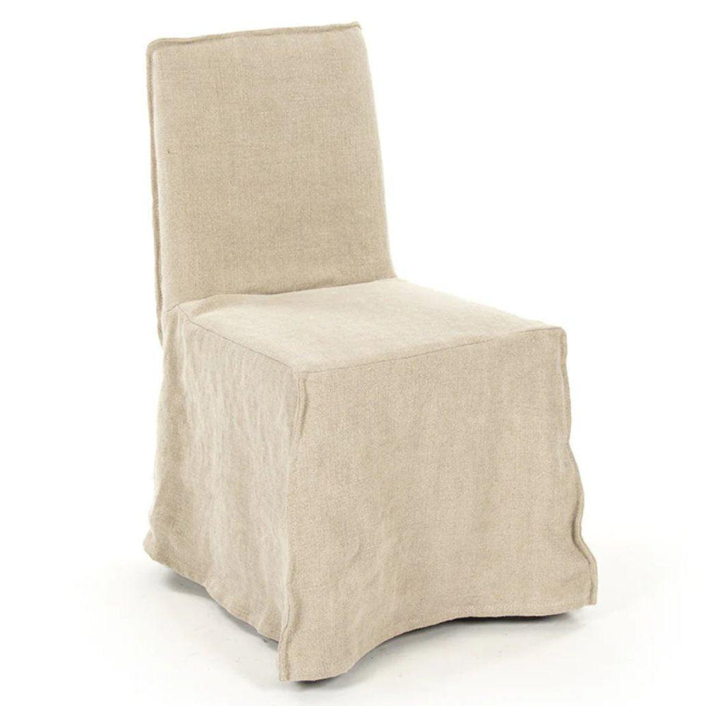 Beige linen slipcovered armchair in a natural boho farmhouse style.