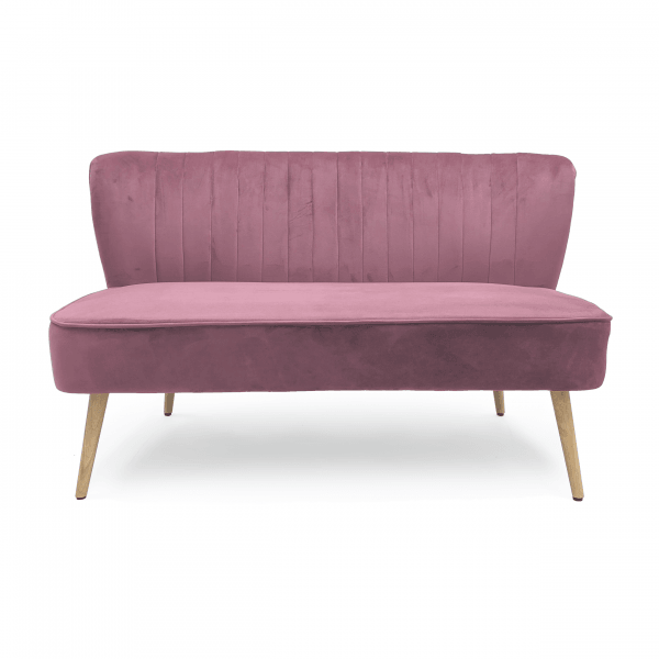 Dusty rose velvet futon sofa with vertical tufting and light wood legs in a modern style.
