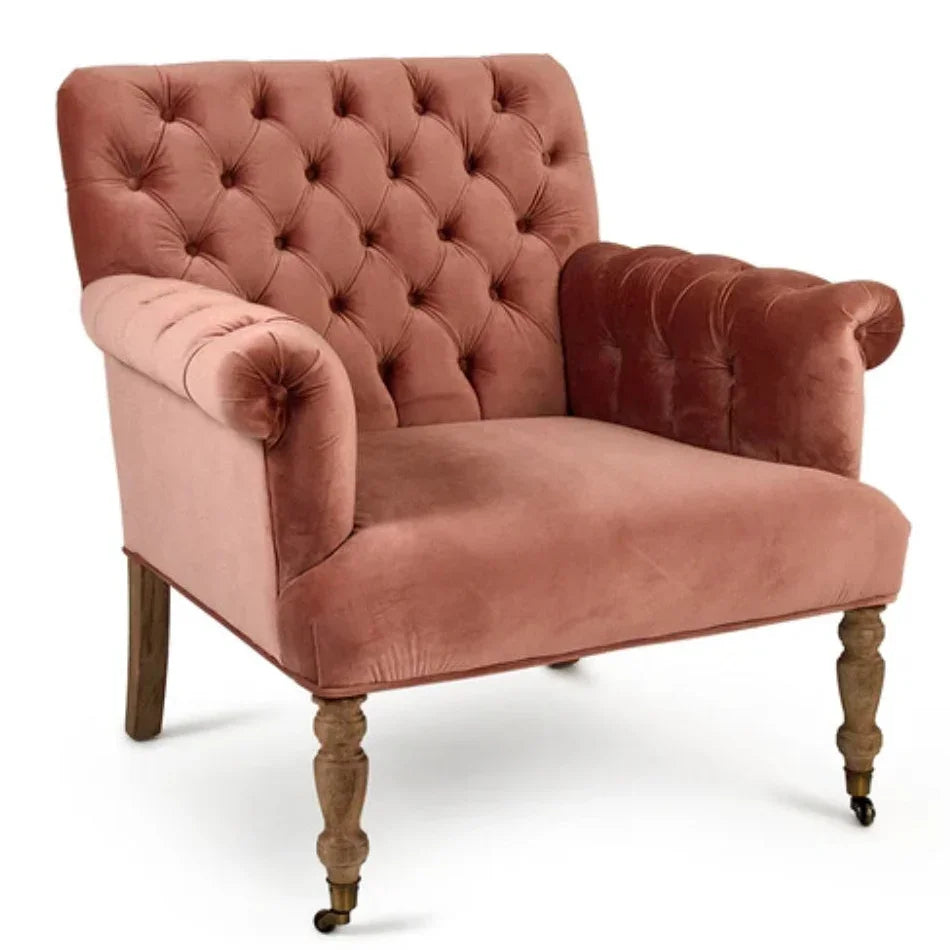 Dusty rose velvet tufted armchair with rolled arms and turned wooden legs in shabby chic style.