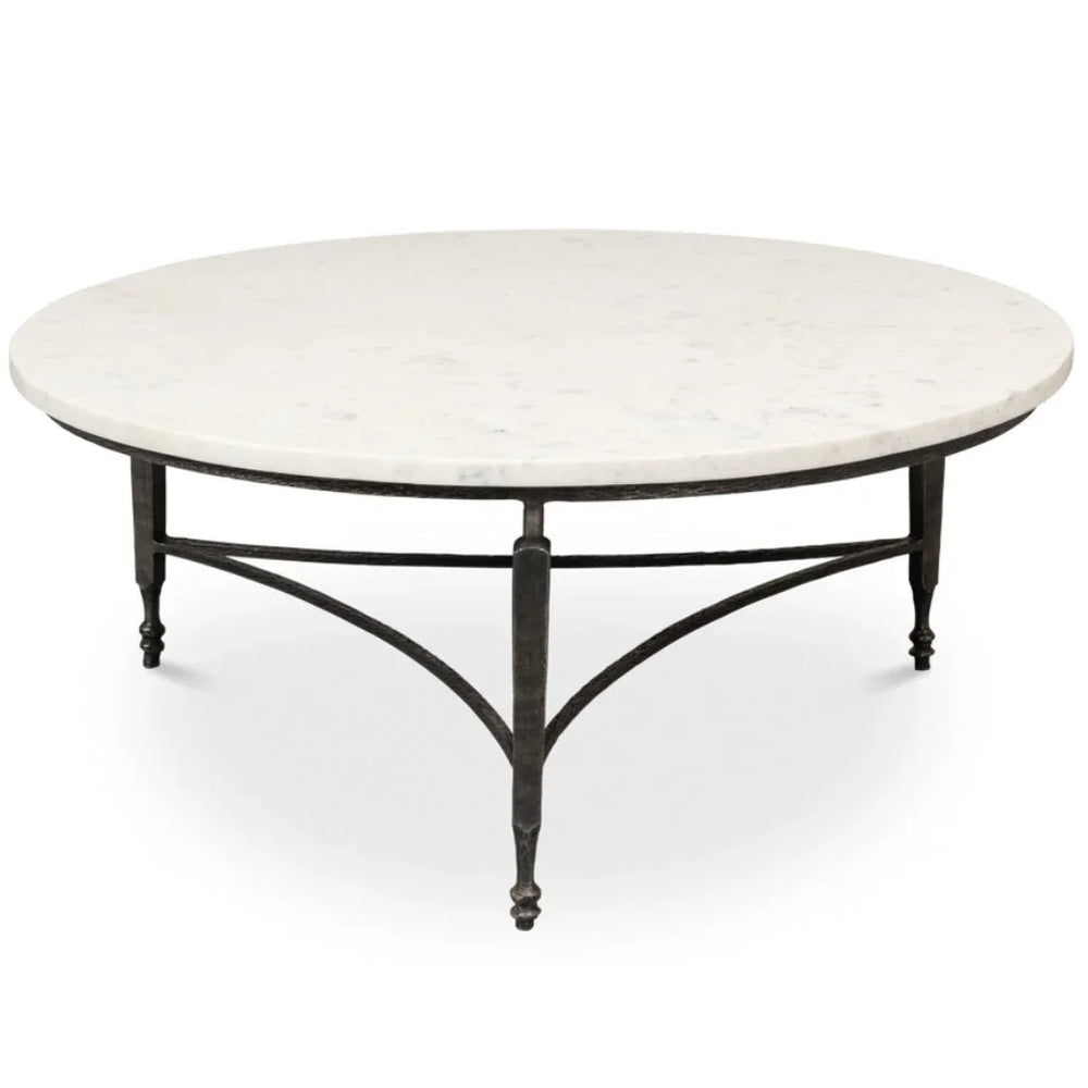 Round white marble coffee table with a dark metal pedestal base in French country style.