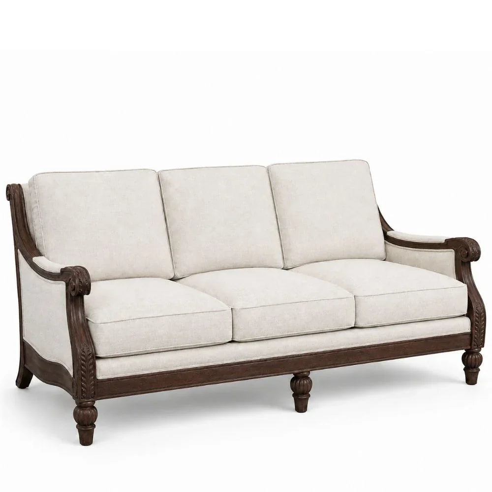 A three-seat sofa with cream-colored fabric cushions and a dark brown carved wooden frame, shown against a plain white background.