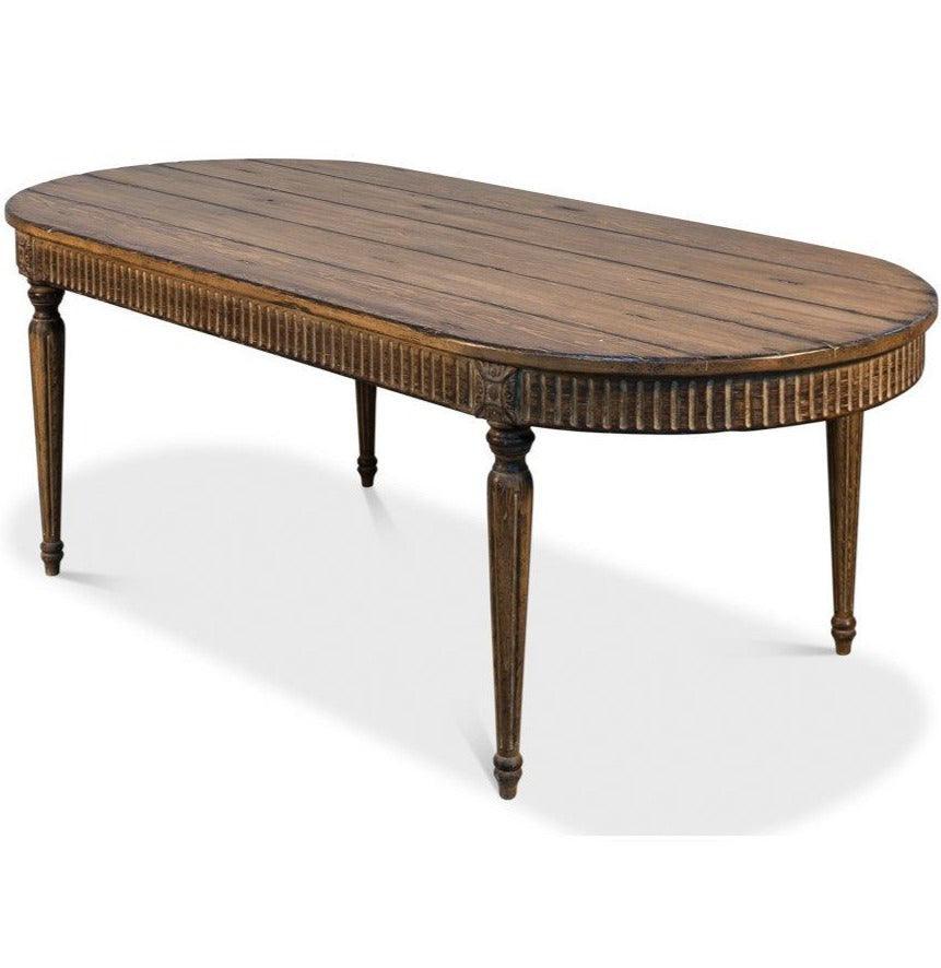 Antique Oval Provincial Louis Style Dining Table in a rich antiqued brown wood stain with a planked top, large carved rosettes and fluted apron and legs- Belle Escape