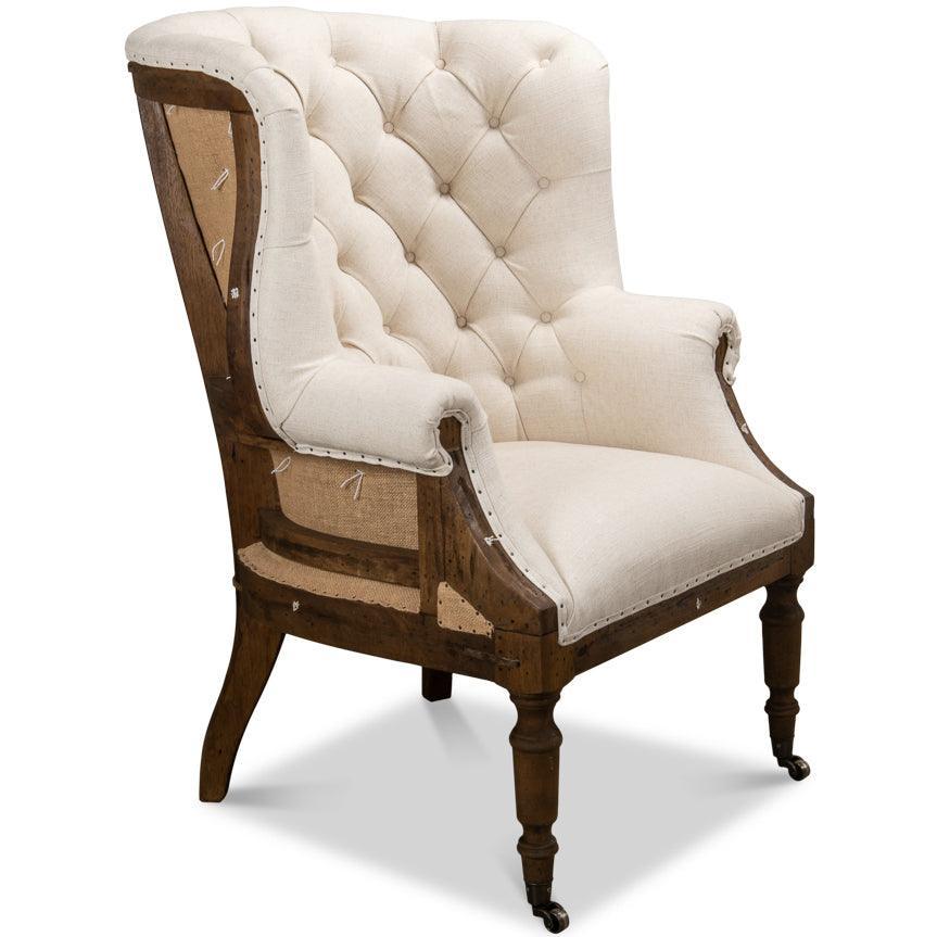 Antique-style wingback chair with tufted cream upholstery and dark wood frame, French country design