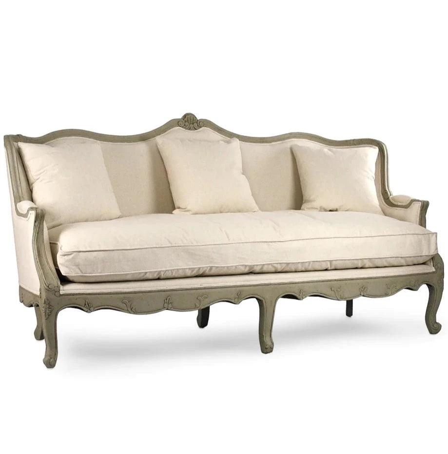Elegant French country sofa with ornate carved frame and neutral upholstery, perfect for shabby chic or farmhouse decor