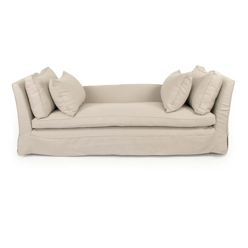 Beige slipcovered French country style sofa with four matching throw pillows.